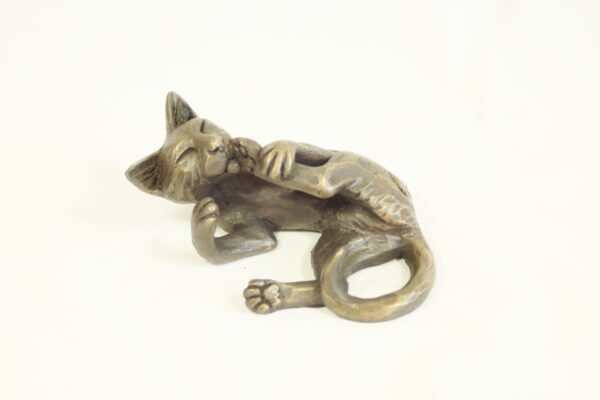 bronze resin Cat lying licking its foot