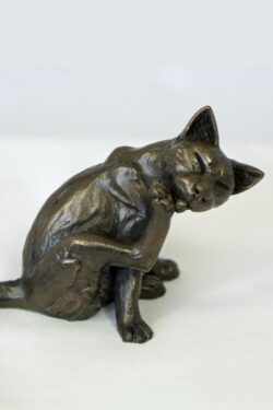 bronze resin Cat sitting licking one paw