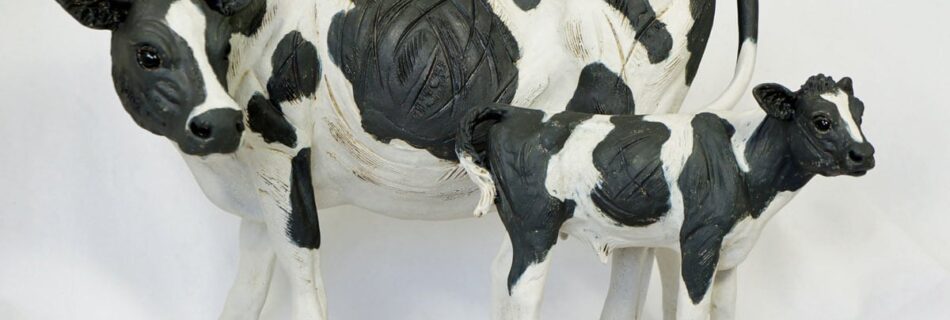 A Black and White Cow with Calf - ceramic clay sculpture